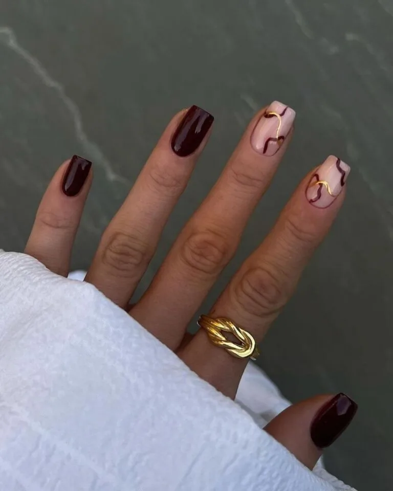Burgundy-nails-with-abstract-gold-lines-