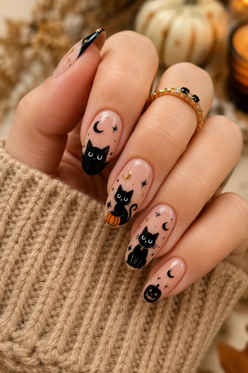 Halloween black cat nails with pumpkin art, crescent moons, stars, and glossy black details on almond-shaped nails with cozy fall style.