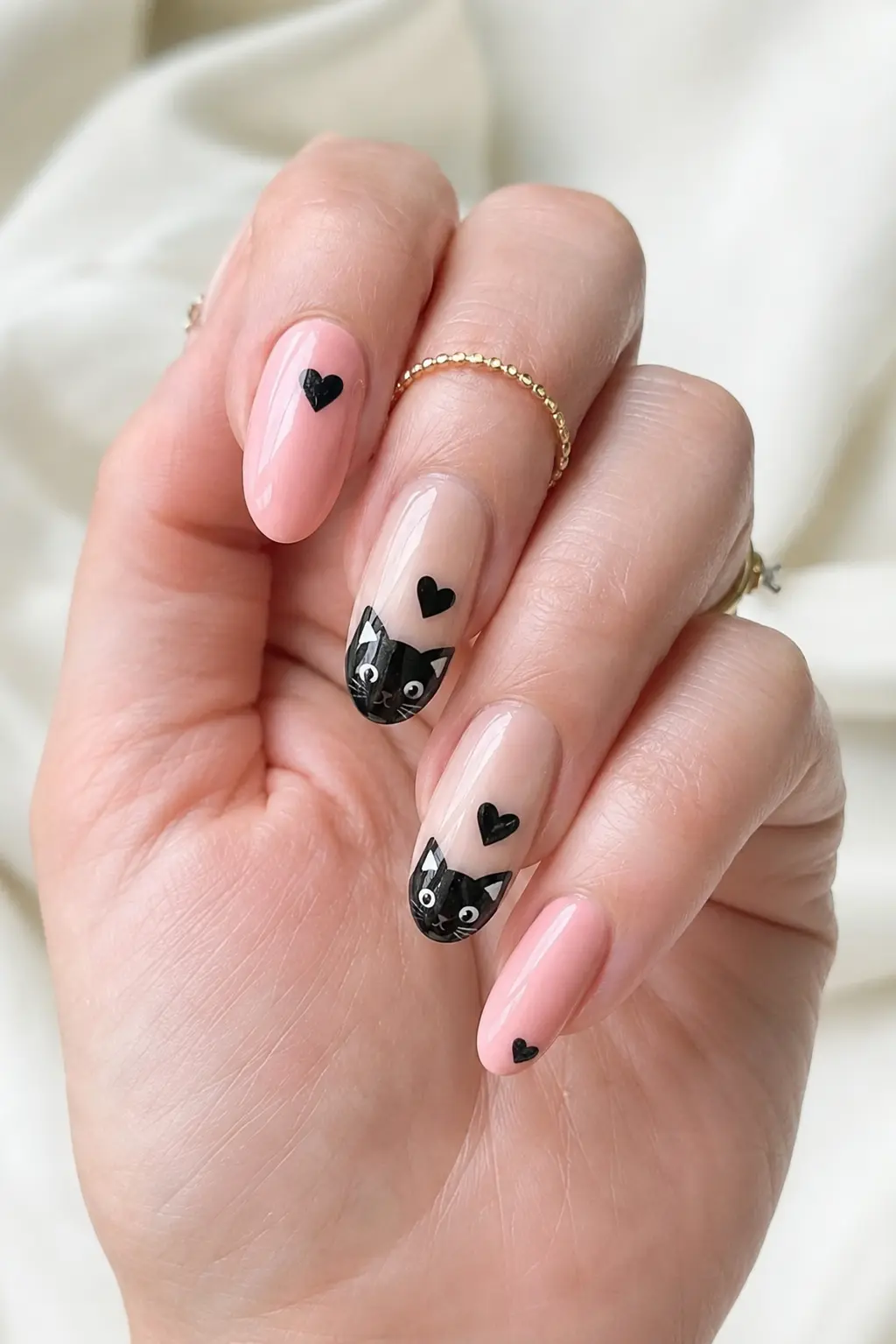 Glossy pink and nude black cat heart nails with cute cat artwork, tiny hearts, delicate rings, and a soft feminine manicure style.