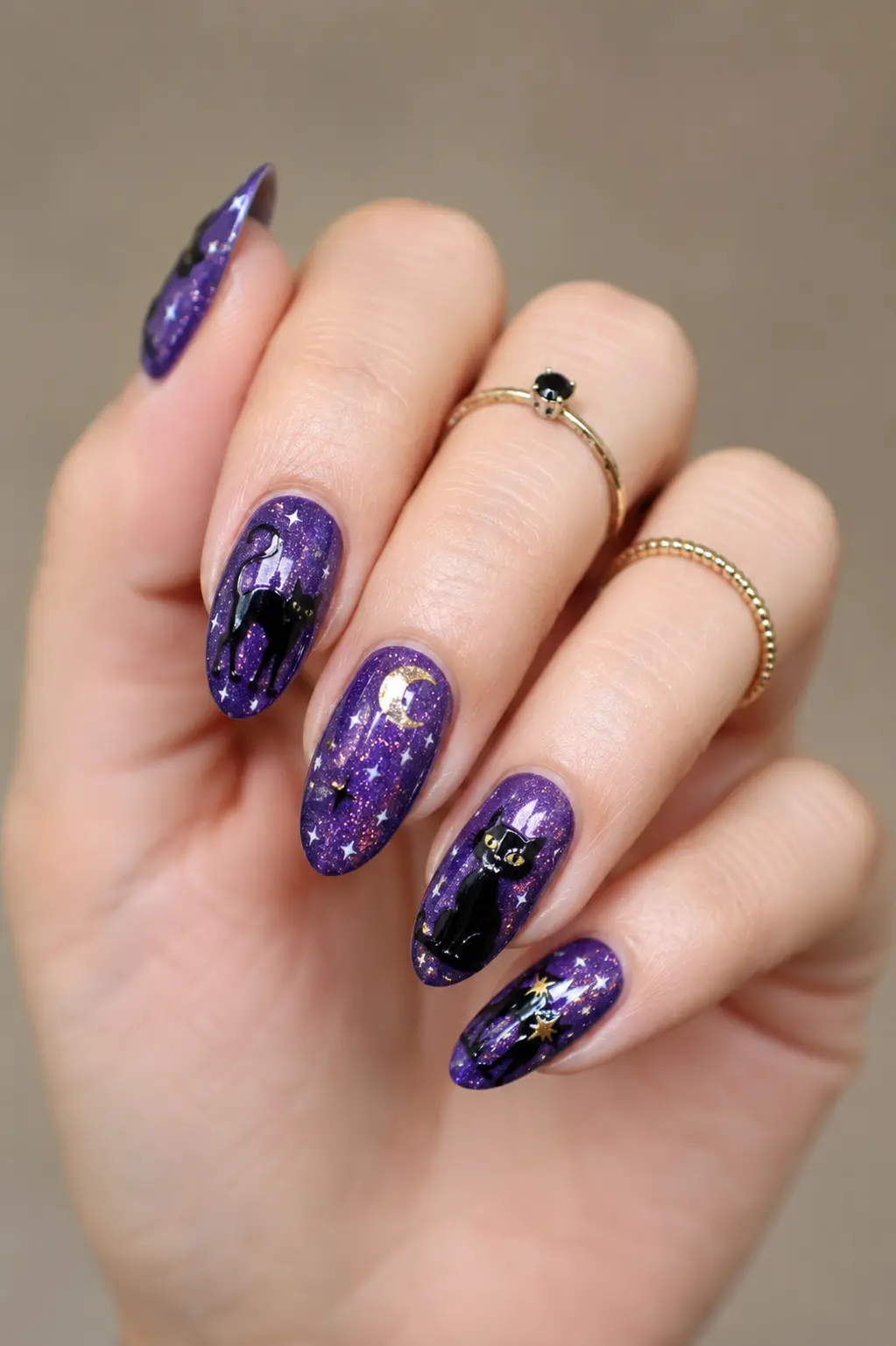 Glossy purple black cat nail art with moon, stars, glitter accents, and magical spooky details on elegant manicured nails.